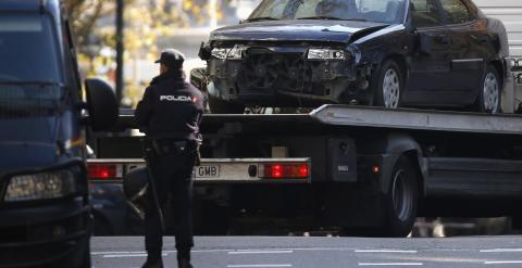 Una grúa traslada el vehículo que un empresario arruinado ha empotrado contra la sede nacional del PP, en la calle Génova de Madrid. REUTERS/Juan Medina