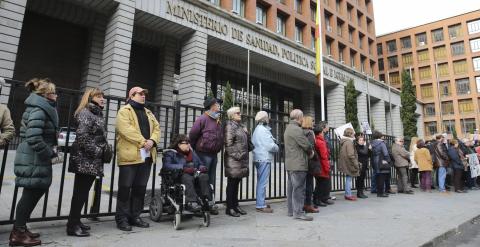 Varias personas participan en una cadena humana, organizada por la Plataforma de Afectados por la Hepatitis C, rodeando el Ministerio de Sanidad para exigir tratamientos para la enfermedad.- EFE/Ballesteros