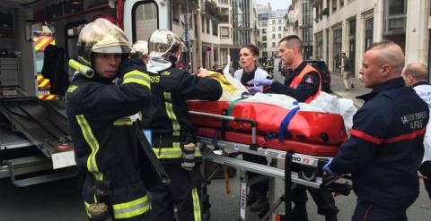 Bomberos meten en una ambulancia a uno de los heridos en el tiroteo en la sede de Charlie Hebdo. /AFP