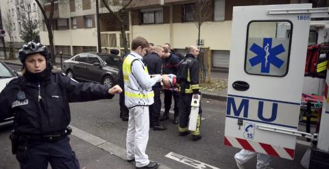 Un agente de Policía da indicaciones en las inmediaciones de la revista 'Charlie Hebdo'. /AFP