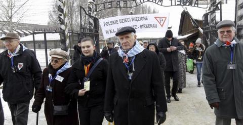 El exprisionero Wieslawa Borysewicz (c) y otros antiguos internos entran en el campo de concentración nazi de Auschwitz. EFE