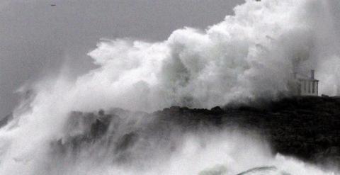 Una ola rompe sobre el faro de la isla de Mouro debido al fuerte temporal. EFE