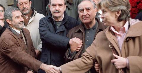 El diputado de IU Gaspar Llamazares estrecha la mano a María Dolores González Ruiz, en presencia de Angel Rodríguez Leal y Miguel Sarabia, tres supervivientes de la matanza de Atocha. (EFE)