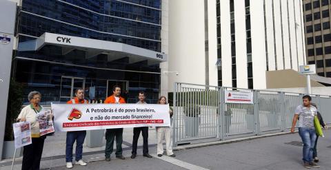 Trabajadores de Petrobras con una pancarta delante de la sede de la empresa pública brasileña, en Sao Paulo. REUTERS/Paulo Whitaker