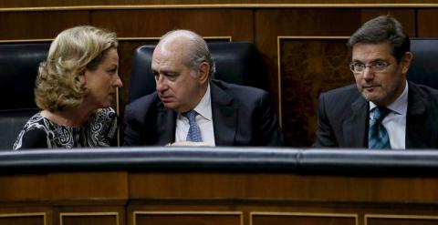 El ministro de Interior, Jorge Fernández (c), conversa con la diputada de Coalición Canaria, Ana Oramas (i), junto al ministro de Justicia, Rafael Catalá (d), hoy durante el pleno del Congreso de los Diputados. /EFE