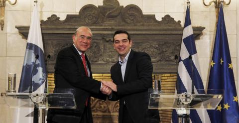 El primer ministro griego, Alexis Tsipras, estrecha la mano al secretario general de la OCDE, José Ángel Gurría, durante una rueda de prensa conjunta tras mantener un encuentro en Atenas. EFE/Alexandros Vlachos