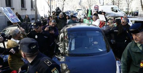 Los preferentistas a la salida del juzgado rodean y golpea el coche de Blesa./ EUROPA PRESS