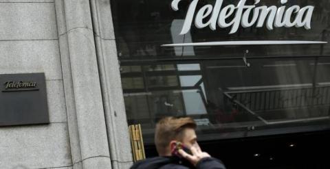 Un hombre habla con su móvil delante de la sede de Telefónica en la Gran Vía madrileña. REUTERS