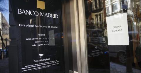 Un cartel colocado en una puerta avisa del cierre de una de las oficinas de Banco de Madrid. REUTERS/Andrea Comas