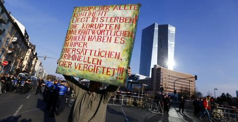 Un manifestante sostiene una pancarta frente a la nueva sede del BCE. REUTETRS