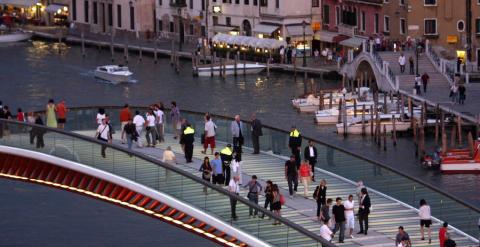 Varia personas cruzan el Puente de la Constitución, en Venecia.