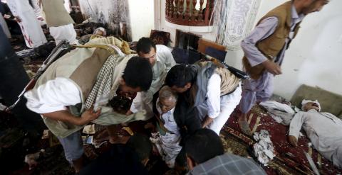Un grupo de personas auxilian a uno de los heridos en el ataque terrorista a una mezquita en la capital yemení de Saná.. REUTERS/Khaled Abdullah