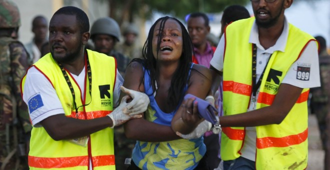Dos sanitarios ayudan a una mujer que ha escapado de la Universidad de Garissa, en el este de Kenia, donde al menos 147 personas han muerto en un ataque con rehenes reivindicado por el grupo islamista Al Shabab.- Dai Kurokawa (EFE)