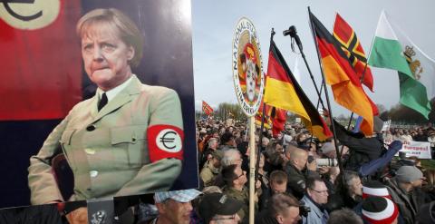 Simpatizantes y seguidores de Peguida, con un cartel de la canciller Angela Merkel, en la manifestación en Dresde.. REUTERS/Fabrizio Bensch