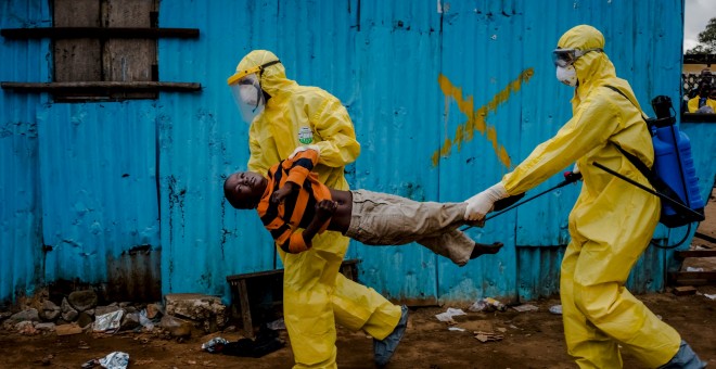 Trabajadores médicos llevan a James Dorbor, 8 años, porque sospechan que pueda tener ébola, a un centro de tratamiento en Monrovia, Liberia./  REUTERS/Daniel Berehulak/The New York Times