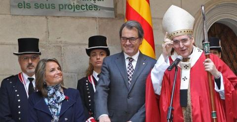 El presidente de la Generalitat, Artur Mas, su esposa, Helena Rakosnik, y el arzobispo de Barcelona, Lluís Martínez Sistach, esta mañana durante la bendición de rosas que se ha celebrado en el patio de carruajes del Palau de la Generalitat./ EFE