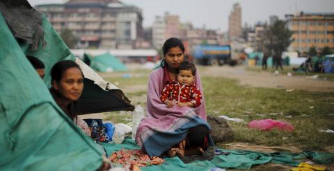 Una víctima del terremoto lleva en brazos a su hermana fuera de su refugio improvisado en las afueras de Katmandú, Nepal./ REUTERS/Adnan Abidi