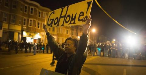 Una mujer muestra una pancarta en la que se puede leer 'Iros a casa' durante una protesta contra la muerte de Freddie Gray en Baltimore (Estados Unidos)./ EFE