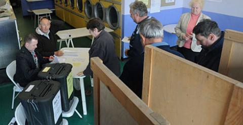 Un grupo de personas deposita su voto en una lavandería de Oxford. /REUTERS