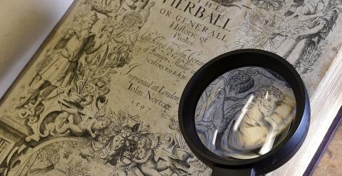 La primera edición de 'The Herball', con la supuesta imagen de Shakepseare ampliada con una lupa.  REUTERS/Toby Melville