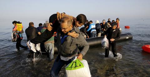 Refugiados sirios en una lancha abarrotada llegando a la isla griega de Kos tras cruzar el Mar Egeo desde Turquía./ REUTERS/Yannis Behrakis