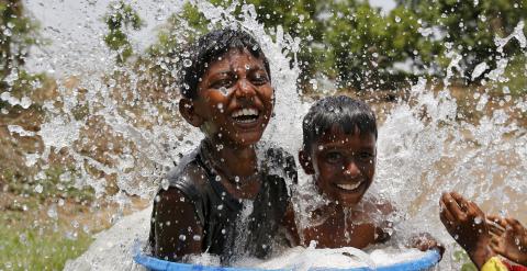 Dos niños indios combaten el fuerte calor. / Amit Dave (Reuters)