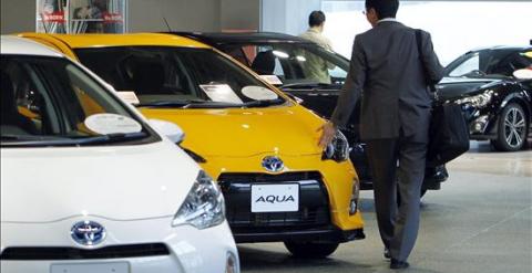 Un hombre observando coches expuestos en un concesionario. EFE