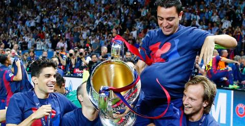 Xavi, con la copa y el balón, levantado por Bartra, Iniesta y Rakitic. Reuters / Kai Pfaffenbach