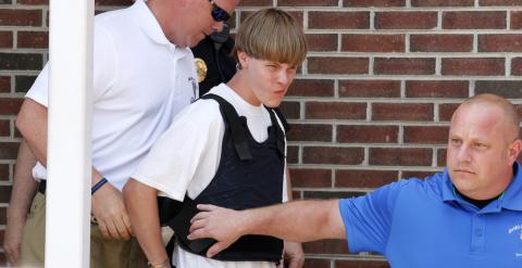 Roof es custodiado por la policía tras ser detenido. REUTERS/Jason Miczek