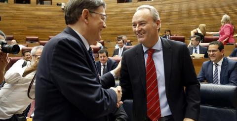 El candidato a la presidencia de la Generalitat, Ximo Puig (d), saluda al presidente de la Generalitat en funciones, Alberto Fabra (d), a su llegada al pleno de Les Corts Valencianes para su investidura