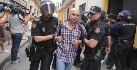David Navarro, concejal de Por Cádiz sí se puede, es llevado por dos policías nacionales durante el desahucio ejecutado  a una familia de la casa donde vivían en Cádiz en régimen de alquiler. EFE/Román Ríos
