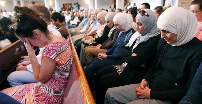Gente de diferentes religiones reza durante una misa en homenaje a las víctimas del atentado de Tennessee, en una iglesia en Chattanooga./  REUTERS/Tami Chappell