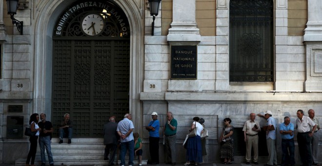 Varias personas esperan para entrar a sucursal del Banco Nacional de Grecia.- YIANNIS KOUROGLOU (REUTERS)