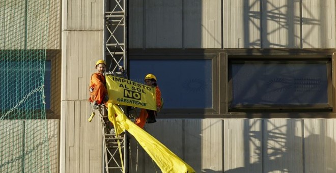Activistas de Greenpeace despliegan una pancarta contra el 'impuesto al sol' en el Ministerio de Industria. -E.P