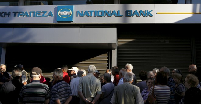 Varios ciudadanos griegos hacen cola para sacar dinero de un cajero durante el corralito.- REUTERS
