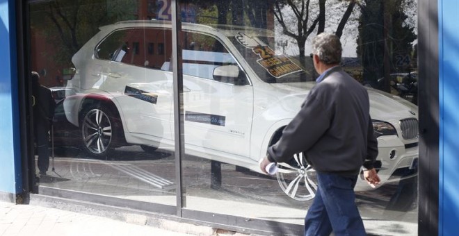 Un peatón pasa por delante de un concesionario de autonóviles. E.P.