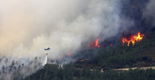Un helicóptero descarga agua sobre el incendio forestal declarado en la Sierra de Gata, en el límite de Cáceres con la provincia de Salamanca. EFE/Carlos García