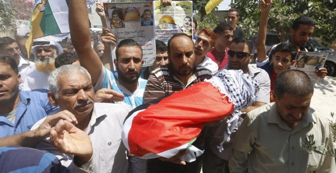 Un grupo de palestinos muestra el cuerpo sin vida de Ali Dawabsha, de 18 meses de vida, durante su funeral en Nablus (Cisjordania) hoy, 31 de julio de 2015. El secretario general de la Organización para la Liberación de Palestina (OLP) y jefe negociador p