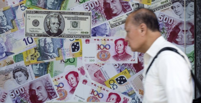 Un hombre camina frente a un anuncio de una casa de cambio en Hong Kong. REUTERS/Tyrone Siu