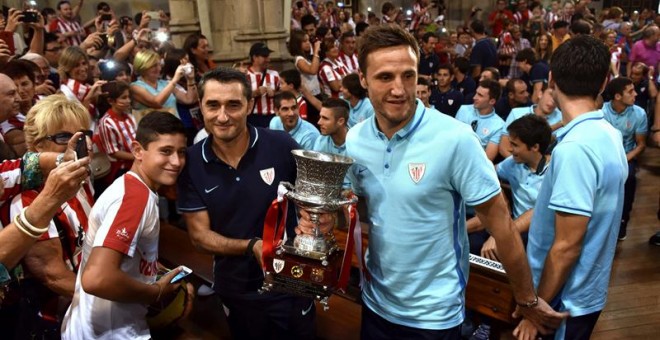 El capitán del Athletic de Bilbao, Carlos Gurpegui, y el entrenador del equipo, Ernesto Valverde, durante la ofrenda de la Supercopa a la Virgen de Begoña, patrona de Bilbao, con la que se han inciado los actos de homenaje que recibe hoy el club con motiv