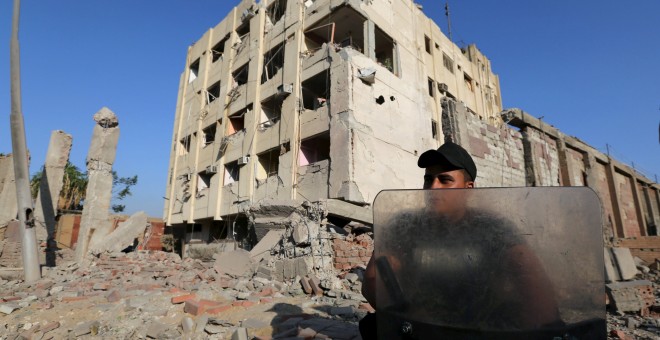 Un agente de policía egipcio junto al edificio donde ha estallado una bomba colocada por el Estado Islámico. REUTERS/Mohamed Abd El Ghany