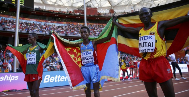 El ganador de la maraton del Mundial de Atletismo, en Pekón, el eritreo Ghirmay Ghebreslassie, entre el segundo clasificado, el etíope Yemane Tsegay (izq) y el ugandés Munyo Solomon Mutai (der). REUTERS/Kai Pfaffenbach