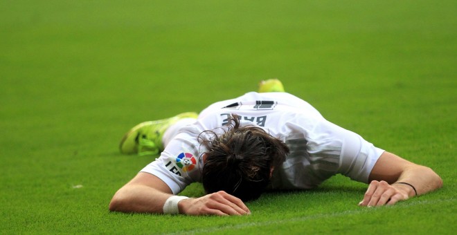 Gareth Bale, tumbado sobre el césped del Molinón.  EFE/José Luis Cereijido