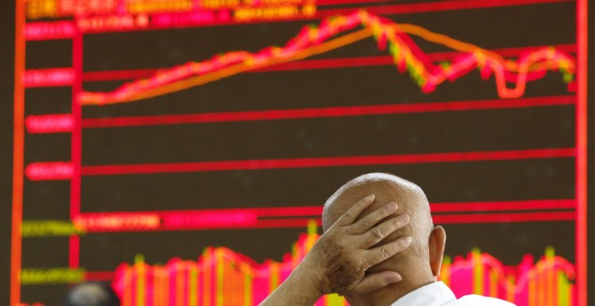 Un hombre contempla los índices bursátiles en la Bolsa de Pekín. REUTERS