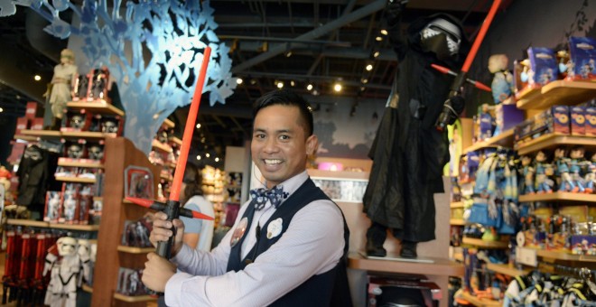 Jake gerente de una tienda Disney en California (EEUU), muestra la nueva espada láser de la película 'Star Wars, el despertar de la fuerza'. EFE/EPA/MIKE NELSON