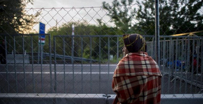 Una mujer observa la frontera entre Serbia y Hungría en Roszke. /EFE