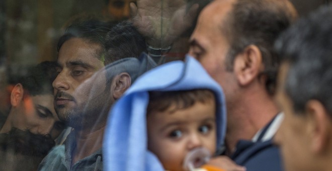Varios refugiados esperan en la oficina extranjera para embarcarse en autobuses con dirección a los centros de refugiados en Bruselas, Bélgica. REUTERS / Yves Herman