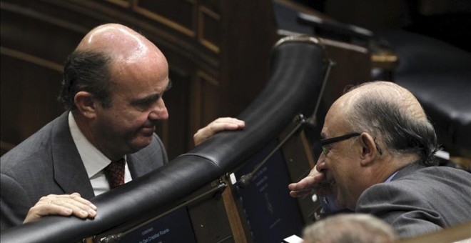 El ministro de Economía, Luis de Guindos, conversa con el ministro de Hacienda, Cristóbal Montoro, en el Congreso de los Diputados. EFE