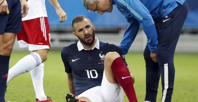 Benzema sentado tras sentir molestias en el partido contra Armenia. /REUTERS