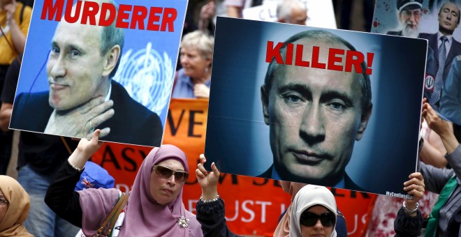 Miembros de la comunidad siria y palestina levantan carteles contra el presidente ruso, Vladimir Putn, en una manifestación en apoyo a los refugiados en  Sydney (Australia). REUTERS/David Gray